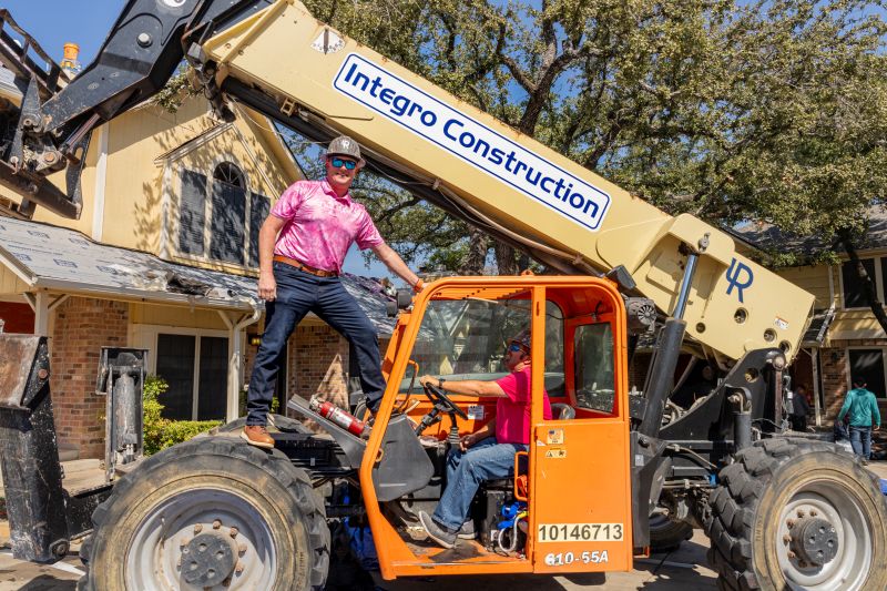 Georgetown construction company Integro Construction Services founder Harley Coons standing on a piece of heavy machinery
