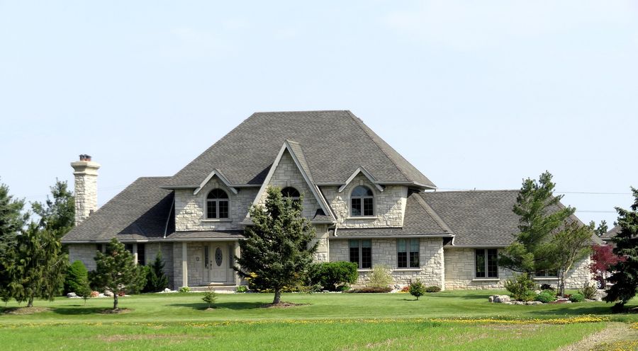 large mansion home with an asphalt shingle roof
