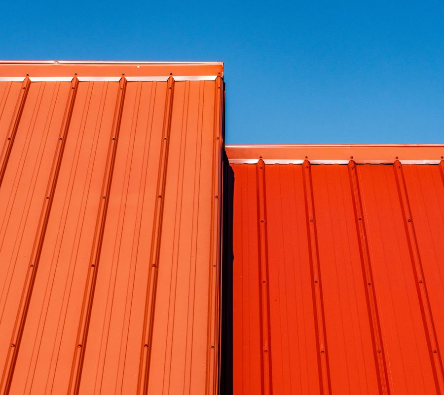 two portions of an orange standing seam metal roof